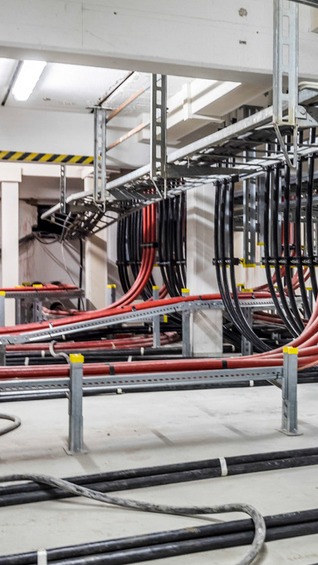Verlegte Stromkabel in einem Umspannwerk, ordentlich in Kabelkanälen geführt