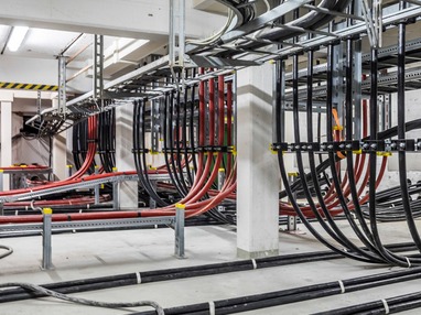 Verlegte Stromkabel in einem Umspannwerk, ordentlich in Kabelkanälen geführt