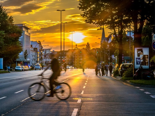 Fahrradfahrer fahren bei Sonnenuntergang auf der Schröderstiftstraße am Schlump in Hamburg